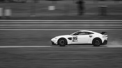 A panning shot of a racing car as it circuits a track.