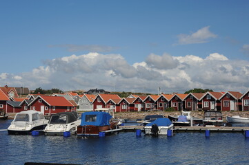 Fototapeta premium Scenic panorama of a waterfront with boats, yachts and houses in Kungshamn (Sotenäs, Västra Götaland, Sweden) on a sunny day in summer