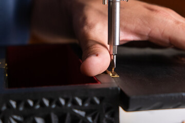 Close-up of a man screwing a hinge into a wooden box. Concept carpentry at home, furniture...