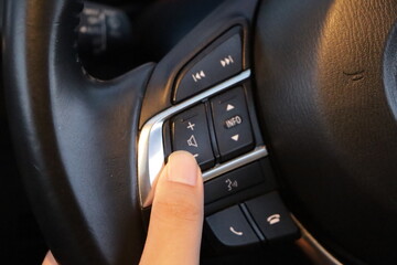 Obraz na płótnie Canvas Women turning button on car radio for listening to music