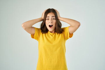 emotional woman in yellow t-shirt with open mouth stress surprise