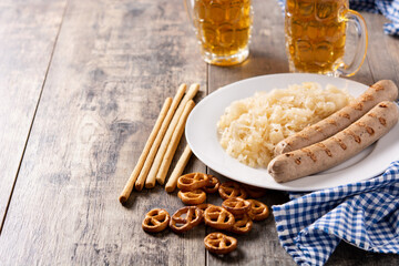 Bratwurst sausage ,sauerkraut, pretzels and beer on wooden table. typical german food	