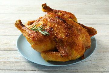 Plate with roast turkey on white wooden table