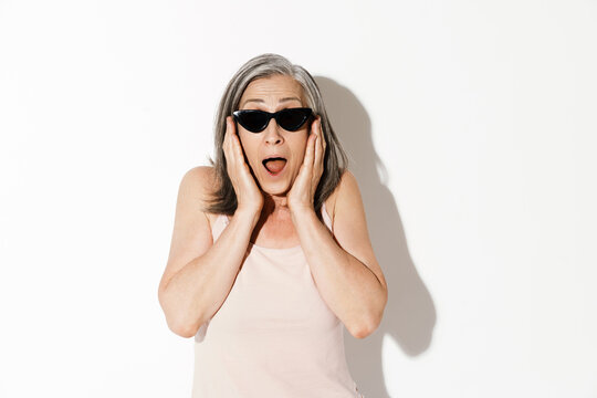 Mature woman in sunglasses screaming while expressing surprise