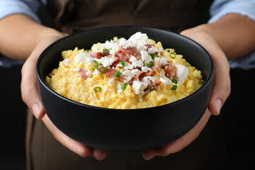 Woman with traditional banosh on black background, closeup