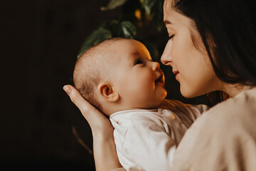 authentic portrait of mother and newborn daughter in her arms. A woman rejoices, hugs and kisses a...