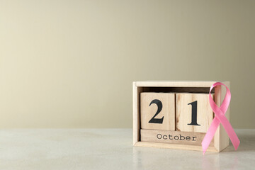 Pink awareness ribbon and wooden calendar with 21 October
