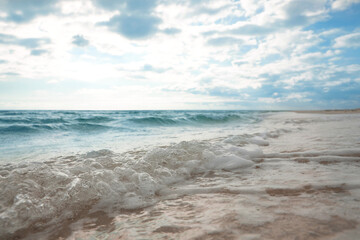Fototapeta na wymiar Sea waves rolling onto sandy tropical beach