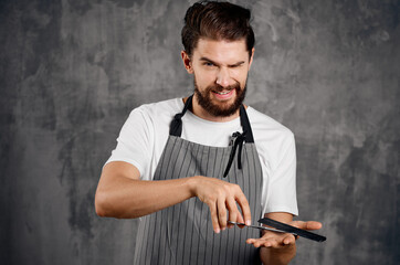 bearded male hairdresser in apron comb scissors service