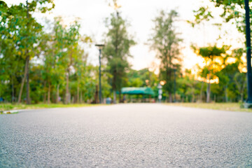 Empty asphalt walking running park road in city sunset green grass