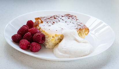 Traditional Swedish cheese cake with fresh raspberry and whipped cream on the plate. Closeup 
