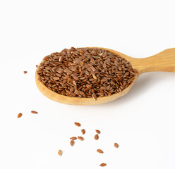 brown dry flax seeds in a wooden spoon on a white background