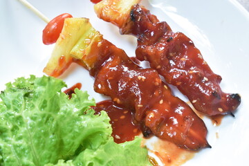 roasted beef meat with pineapple chili and tomato dressing barbecue sauce stabbing wooden stick on...