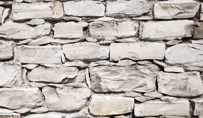 a stone wall made of cobblestones and bricks in the form of a texture as a background for a picture