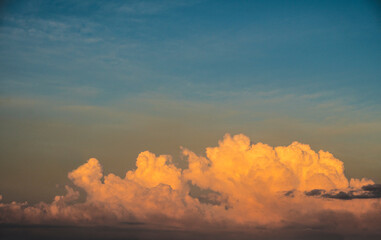 Dramatic clouds lit by the sun at sunset and reflection in the water of the Lake