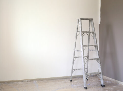 Aluminium ladder in empty room of new house for technician use to higher jobs. Image with copy space