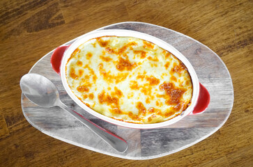 Lasagna in red bowl with spoon, Top view