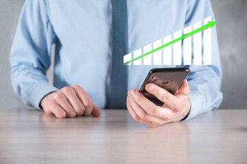 Businessman man holding a graph with positive profits growth. plan graph growth and increase of chart positive indicators in his business.more profitable and growing
