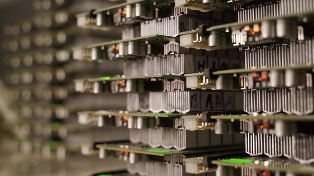 ASIC printed circuit boards with aluminum radiators in repair service center warehouse. Bitcoin miners electronic PCB component parts stacks for replacement. Cryptocurrency mining equipment.