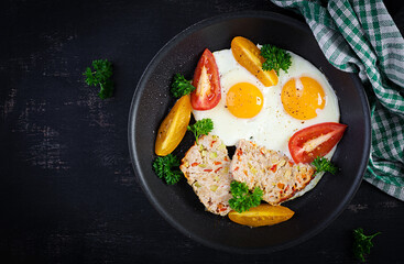 Plate with a keto diet food. Fried egg, meatloaf, and tomatoes. Keto, paleo breakfast. Top view, flat lay