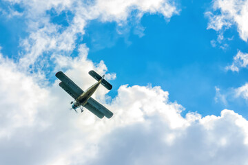 Beautiful biplane in flight on a cloudy sky. Air transport. Sport. Agriculture.