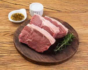 Sliced raw ancho beef, typical argentinian cut, over wooden board with seasonings