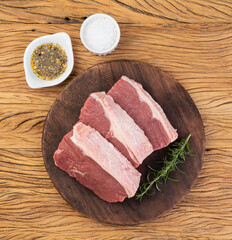 Sliced raw ancho beef, typical argentinian cut, over wooden board with seasonings