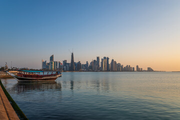 Traditional dhow on a background of a modern city of West Bay Doha, Qatar. - obrazy, fototapety, plakaty