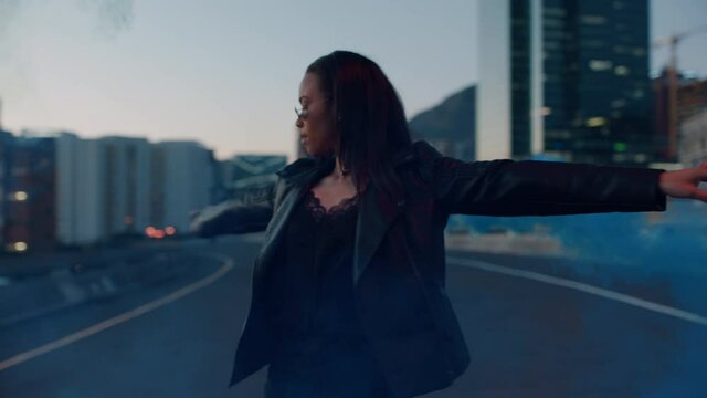 woman dancing with smoke grenade in city at sunrise rebellious girl enjoying dance in street