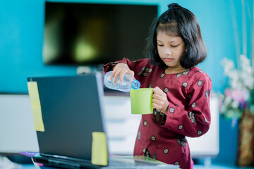 The girl at home communicates with friends on the Internet. Kids distance learning. Cute little girl using laptop at home. Education, online study, home studying, schoolgirl children lifestyle concept