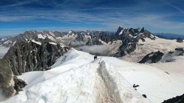 Alpinists reaching top of Aiguille du midi, chamonix, in Swiss Alps. Sport at snowy mountain in Europe. 