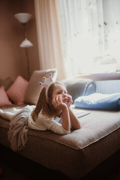 Angry little girl in a costume is lying on the bed.