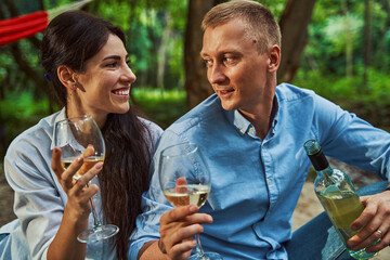 Happy young couple enjoying drinks in nature