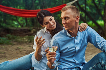 Happy woman drinking wine with beloved man outdoors