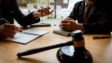 A male lawyer consults a team of legal clients and businessmen who are negotiating contracts. Human...