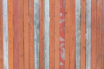 Orange flaky paint on a wooden fence.