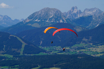 two friends paragliding in the Alps of the Dachstein region in Austria