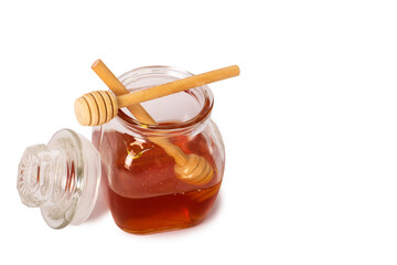 good isolated of Glass jar full of honey and wooden stick on a white background. Honey with wooden honey dipper. Close-up of Glass can full of honey and wooden stick on it. Clipping paths. Studio shot