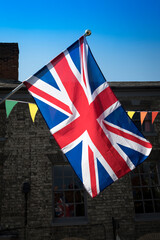 Union Jack and bunting backlit in market town

