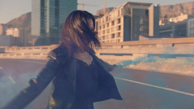 woman dancing with smoke grenade in city at sunrise rebellious girl enjoying dance in street