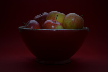 colorful bowl with green and red apples on a dark background