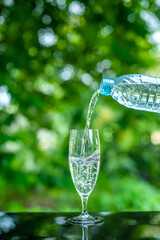 Pouring clean drinking water into the glass located on the bar.