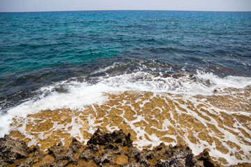 sea coast on the background of a stone shore with a rising wave