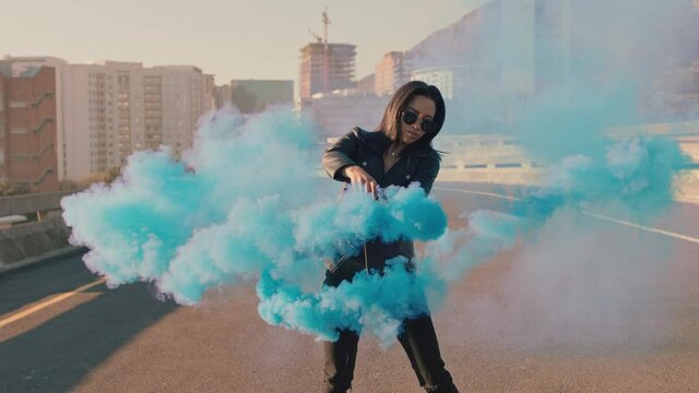 girl dancing with blue smoke grenade in city street young woman hip hop dancer celebrating creative expression with dance slow motion