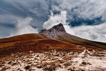 Dramatic sky and landscape image surrounding rock mountain and valley