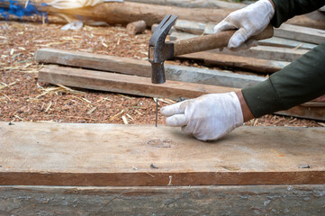 Construction workers hammer nails to install wood patterns