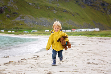 Cute child, running on a Norway white sand beach in the summer