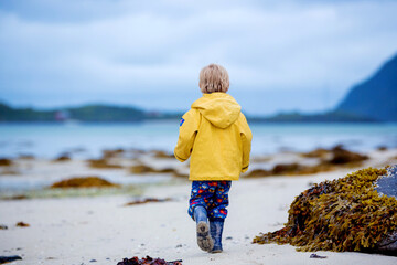 Cute child, running on a Norway white sand beach in the summer