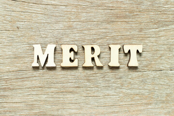 Alphabet letter in word merit on wood background