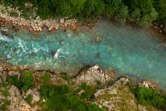 Mountain beautiful river with clear blue water, in the middle of the forest and stones. Natural untouched nature. Top view.